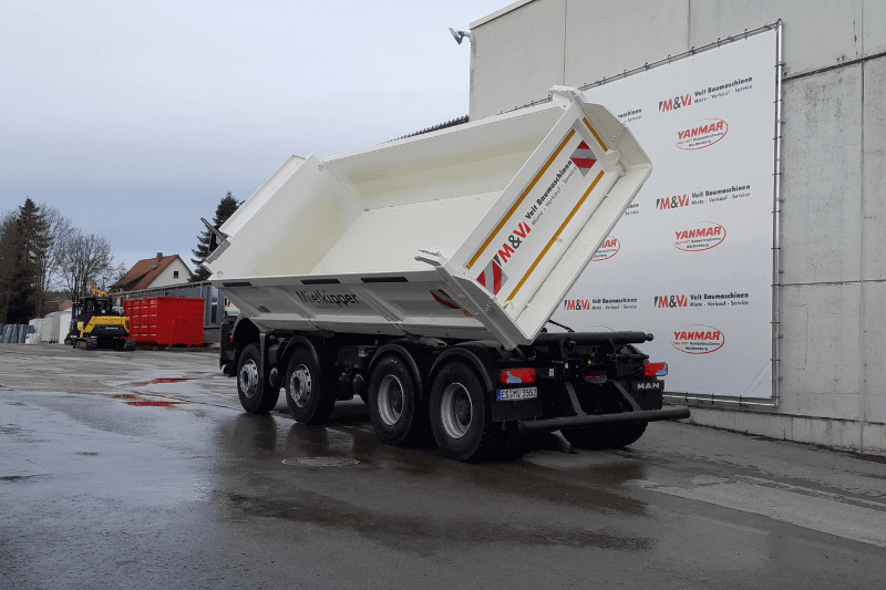 Der MAN TGS 35.510 8x4 BB Kipper von schräg hinten