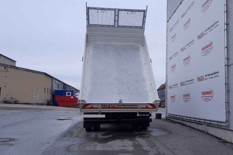 Der MAN TGL 8.190 4X2 BB Kipper von Veit Baumaschinen aus der rückseitigen Perspektive bei der Entladung